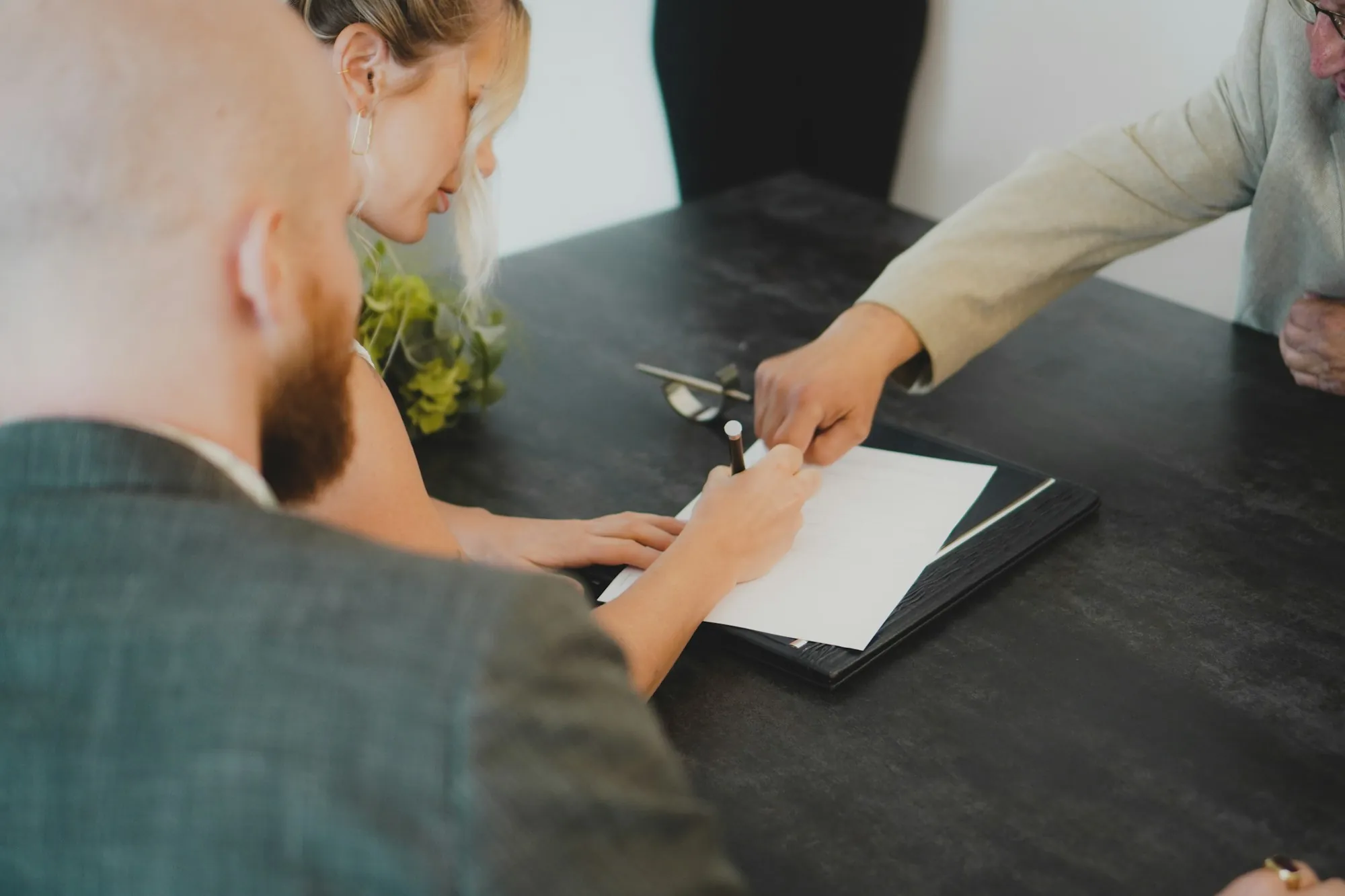 Two people reviewing forms across a dark table